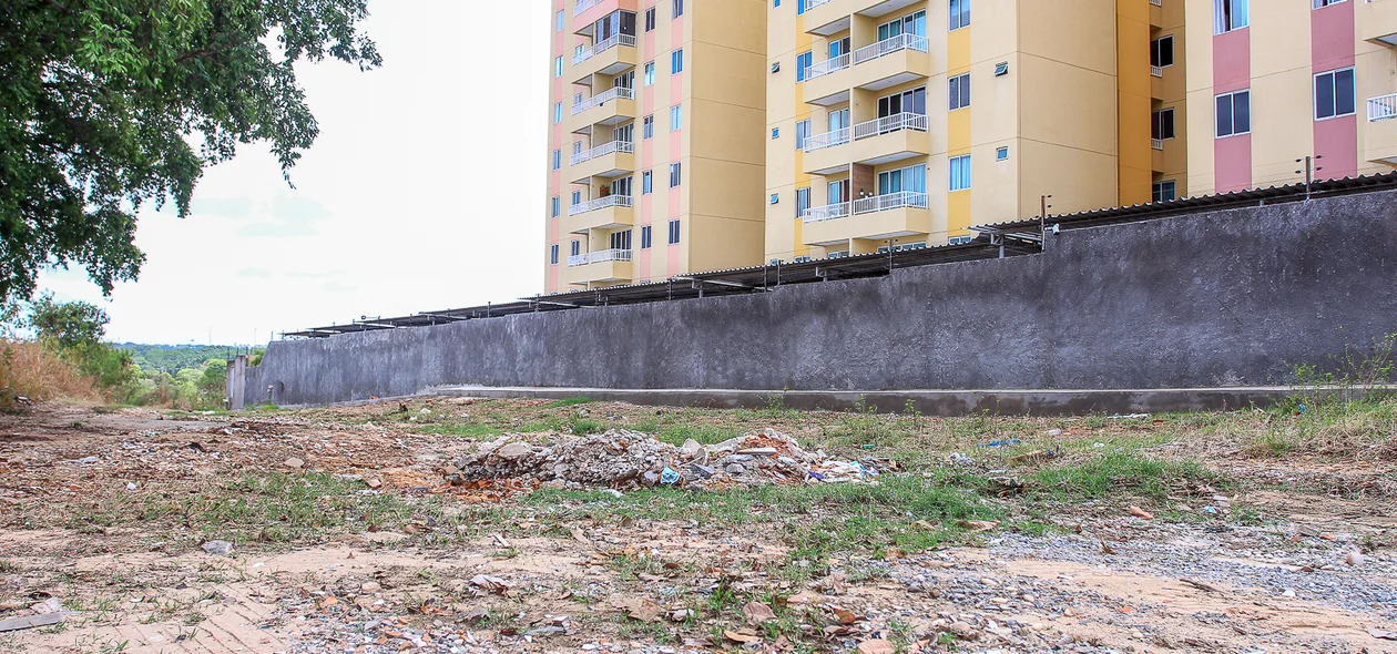 Rua ao lado de condomínio sem calçamento 