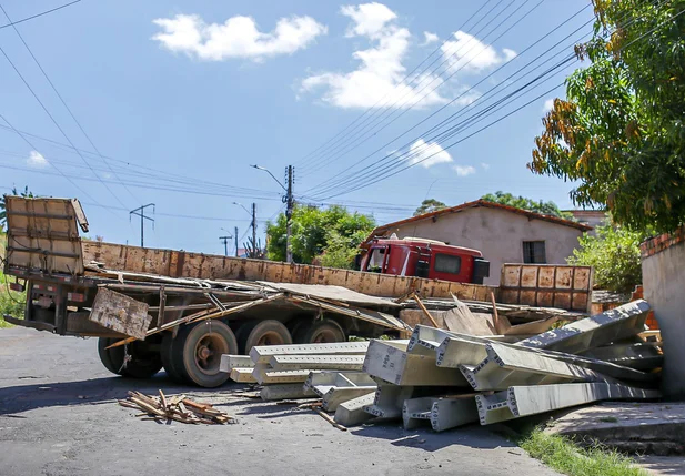 Caminhão carregado de postes perde controle e tomba na zona Leste