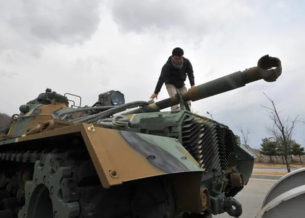 Um homem sul-coreano checa um tanque de guerra na cidade f
