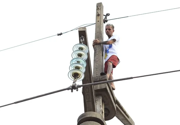 Bombeiros tentam resgatar homem que subiu em poste
